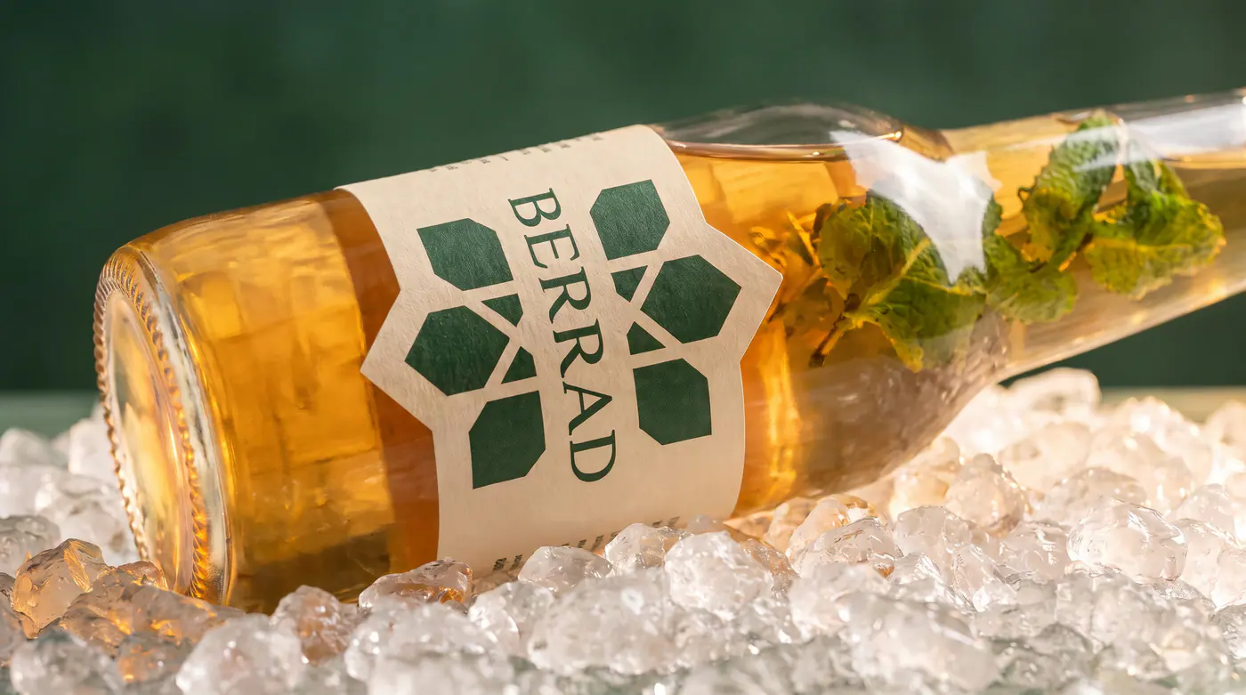Une bouteille de Berrad couchée sur de la glace pilée, couverte de buée