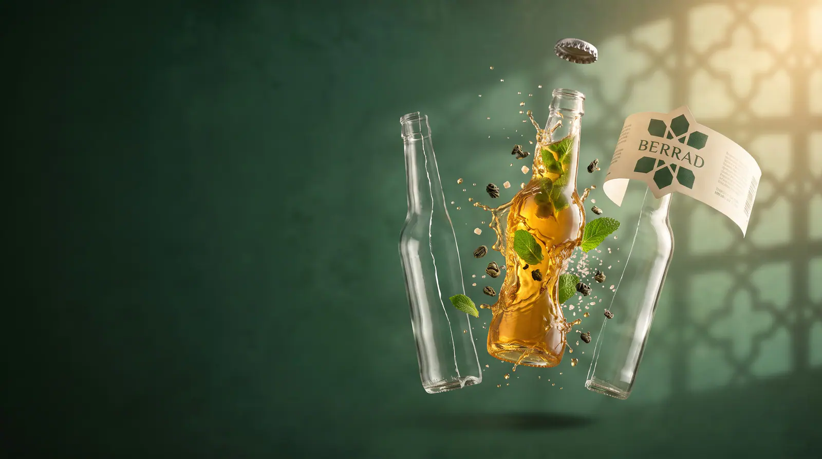 La même bouteille ouverte en pièces détachées : la capsule, l’étiquette, les deux moitiés du verre, et le thé qui garde la forme de la bouteille entouré de menthe, de perles de thé et de sucre